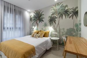 Schlafzimmer mit einem Bett mit Palmen an der Wand in der Unterkunft Viriato - Wifi - AC - Terraza compartida in Guanarteme
