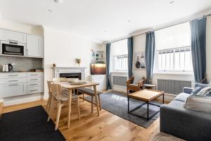 a kitchen and living room with a table and a couch at Fabulous Chelsea 2 bed in London