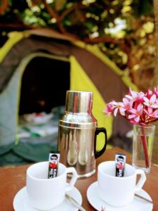 um bule de chá e duas chávenas numa mesa em Akoya Beach Sunset Camp em El Nido