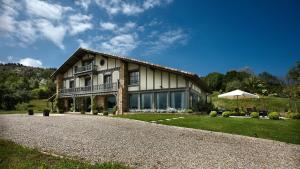 a house with a gravel driveway in front of it at Hotel Iturregi in Getaria