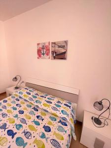 a bedroom with a bed with a colorful comforter at Bilo Giacomo a 150 m dal mare in Marcelli +8 photos