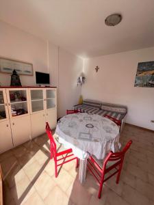 a dining room with a table and two red chairs at Bilo Giacomo a 150 m dal mare in Marcelli