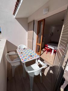 a table and chairs in a room with a balcony at Bilo Giacomo a 150 m dal mare in Marcelli