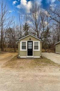 a small yellow house with a door in a yard at Luxurious and Cozy Cabin in a Rural setting - 8 