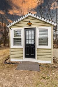 a small house with a black door and windows at Luxurious and Cozy Cabin in a Rural setting - 8 