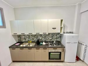 een keuken met witte kasten, een fornuis en een koelkast bij Apartment NAPOLI MARADONA in Napels