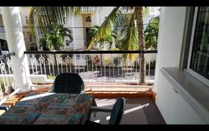 a balcony with a table and chairs and a window at Charming apartment about 120m from the beautiful beach of Trou aux Biches. in Trou aux Biches