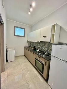 una cucina con piano cottura e frigorifero di Apartment NAPOLI MARADONA a Napoli