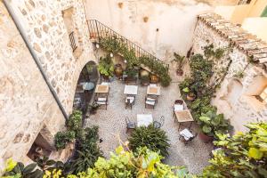 uma vista sobre um pátio com cadeiras e plantas em Hotel Nord em Estellencs