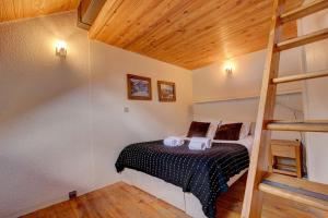 ein Schlafzimmer mit einem Bett in einem Zimmer in der Unterkunft Iris Triplex studio in Chamonix-Mont-Blanc