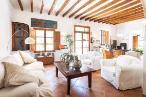 una sala de estar con sofás blancos y una mesa. en Hotel Nord, en Estellencs