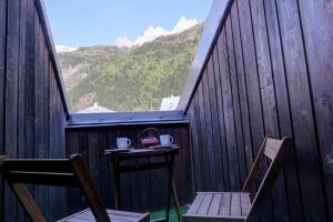 einen Tisch und Stühle auf einem Balkon mit Bergblick in der Unterkunft Iris Triplex studio in Chamonix-Mont-Blanc