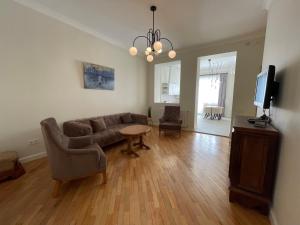 a living room with a couch and a table and a tv at Shveli Apartment in Batumi