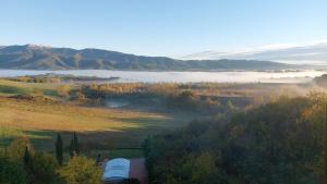 a train traveling through a field with a foggy valley at Tenuta i Lecci in Terranuova Bracciolini