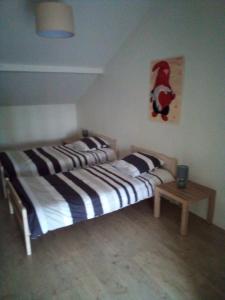 two twin beds in a room with a table at L'OASIS maisonnette centre ville 3 chambres terrasse espace vert privé parc sainte croix center parc 20 minutes in Sarrebourg +30 photos