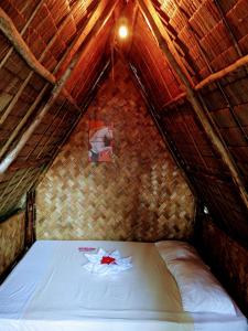 a bed in a room with a roof at Akoya Beach Sunset Camp in El Nido