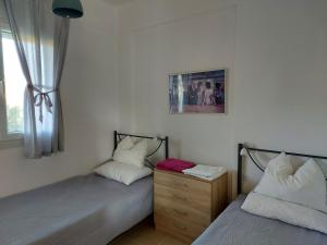 dos camas sentadas una al lado de la otra en una habitación en Port bay view, Porto Coufo, en Porto Koufo