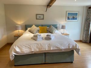 a bedroom with a bed with towels on it at Great Coombe, Bookham Court in Dorchester