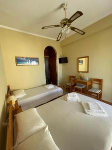 a bedroom with two beds and a ceiling fan at ANESIS I in Livadion