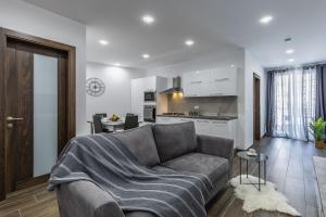 ein Wohnzimmer mit einem Sofa und einer Küche in der Unterkunft Sandstone A8 Marsascala - 15minute drive to Valletta in Marsaskala