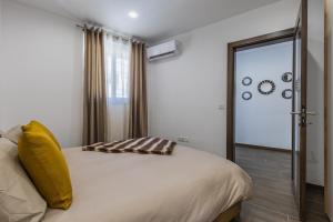 a bedroom with a bed with a yellow pillow on it at Sandstone A8 Marsascala - 15minute drive to Valletta in Marsaskala