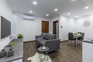 a living room with a couch and a table at Sandstone A8 Marsascala - 15minute drive to Valletta in Marsaskala
