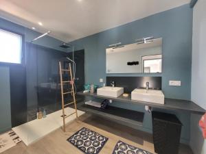 een badkamer met 2 wastafels en een spiegel bij JOLIE MAISON BOIS 8 à 10 personnes in Saint-Jean-de-Monts