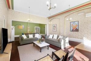 een woonkamer met 2 banken en een tafel bij The White House Fitzroy - One of the largest single dwelling accommodations in Melbourne