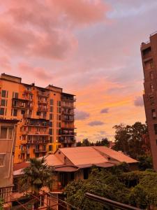 a group of buildings with a sunset in the background at Shveli Apartment in Batumi