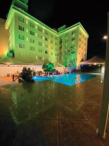 a large building with a pool in front of it at Pride Hotel Bhopal in Bhopal