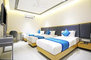 Habitación de hotel con 2 camas y escritorio en Applewood Residency - Free Airport transffer en Nueva Delhi