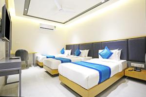ニューデリーにあるHotel Applewood Residency - Offering Free Airport Dropのベッド2台と机があるホテルの部屋