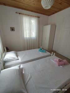 ein Schlafzimmer mit zwei Betten und einem Fenster in der Unterkunft Dina's House in Agía Thékli