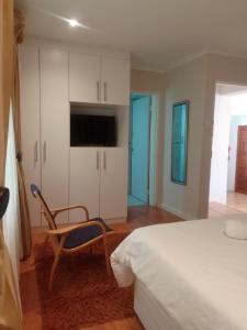 1 dormitorio con 1 cama, 1 silla y TV en Botleng Guest House en Boqate