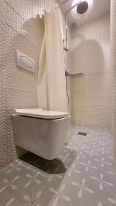 a bathroom with a white toilet and a shower at Signal Appartments in Abidjan