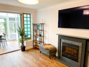 a living room with a fireplace with a flat screen tv at Hydeaway beautiful 3 bedroom house in a great location in Bournemouth