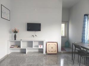 a living room with a tv on a white wall at Deccan Stay in Hyderabad