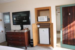 Zimmer mit einem TV, einem Kühlschrank und einer Mikrowelle. in der Unterkunft The Bonnie Inn Unit 1 in San Andreas