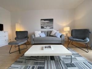 un soggiorno con divano e 2 sedie di Simmerdeis am Hafen a Husum