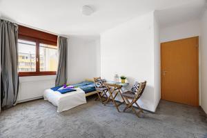um quarto com uma cama, uma mesa e cadeiras em High Class Residence Leopold em Budapeste