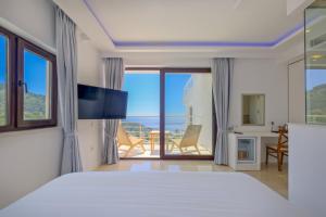 a bedroom with a bed and a view of the ocean at Highclere Hotel and Spa in Faralya