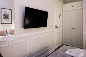 uma sala de estar com uma televisão de ecrã plano na parede em Imagine Apartments em Cracóvia
