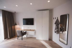 Zimmer mit einem Schreibtisch und einem TV an der Wand in der Unterkunft Weingut Gehlen-Cornelius in Brauneberg