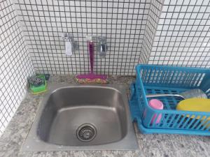 a sink with a faucet and a basket next to it at Deccan Stay in Hyderabad