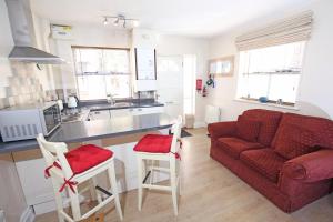 a living room with a red couch and a kitchen at Thirsk Stays - Bakery Cottage in Thirsk