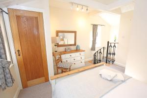 a bedroom with a bed and a dresser and a mirror at Bakery Cottage Thirsk in Thirsk