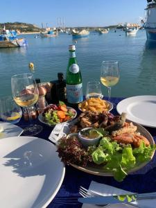 - une table avec des assiettes de nourriture et des verres de vin dans l'établissement Sunrise Apt - Modern Studio Apt near the Beach, à Birżebbuġa