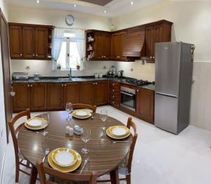 a kitchen with a table with chairs and a refrigerator at Sunrise Apt - Modern Studio Apt near the Beach in Birżebbuġa