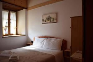 1 dormitorio con 1 cama y 2 ventanas en La Tana del Tasso Rooms&Breakfast, en Camerata Cornello