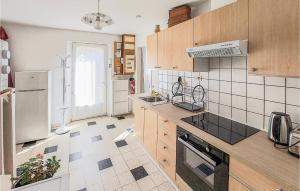 kuchnia z lodówką i kuchenką górny piekarnik w obiekcie Amazing Home In Péronne With Kitchen w mieście Péronne